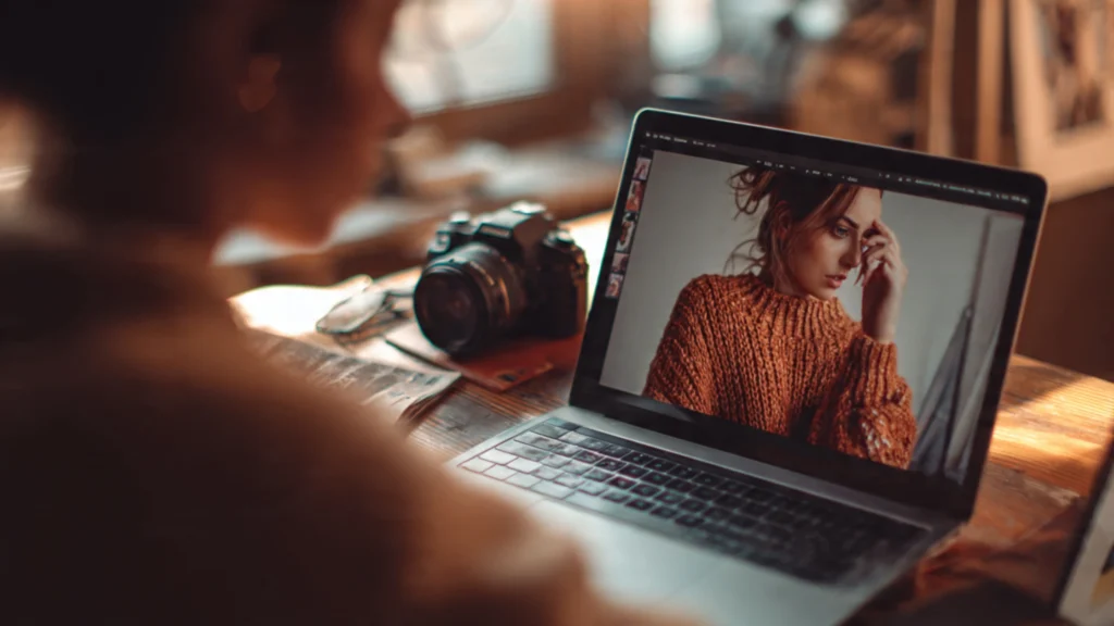 someone working on a photography portfolio on a laptop here